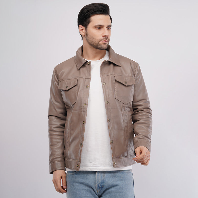 Man wearing a brown leather jacket over a white shirt on a light gray background