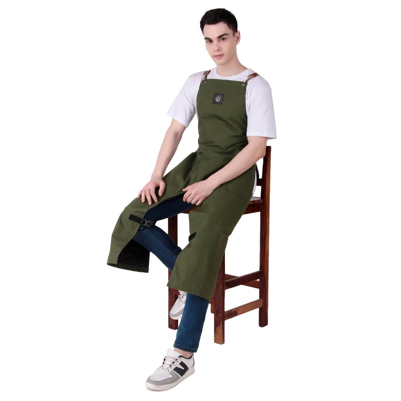 Person wearing a green apron sitting on a wooden stool against a white background