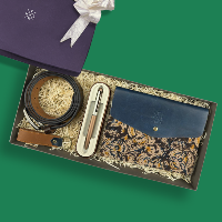 Gift set with blue leather wallet, belt, and pen in a box on a green background
