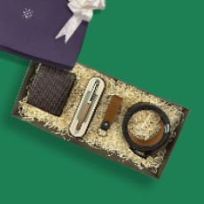 Gift set with wallet, pen, keychain, and belt in a box on a green background
