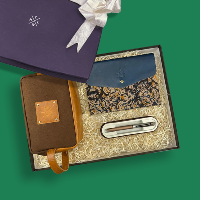 Gift set with brown leather pouch, blue floral clutch, and silver pen on a green background