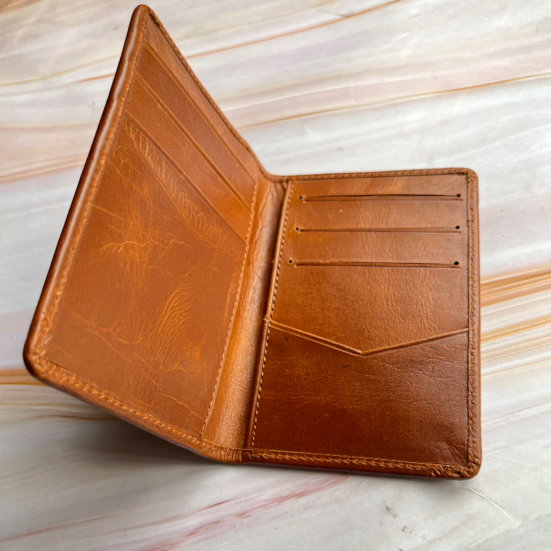 Brown leather wallet on a light wooden surface