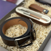 Brown leather belt with silver buckle on a textured surface