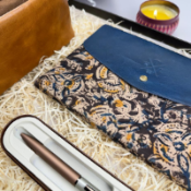 Patterned sleeve with a blue cover and pen set on a textured surface