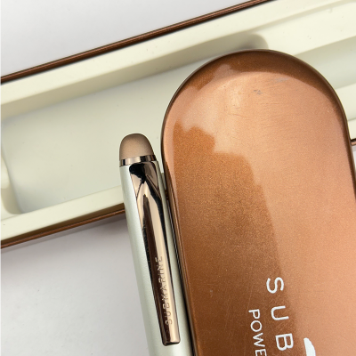 Makeup brush and compact powder with 'Sculpted' branding on a white background