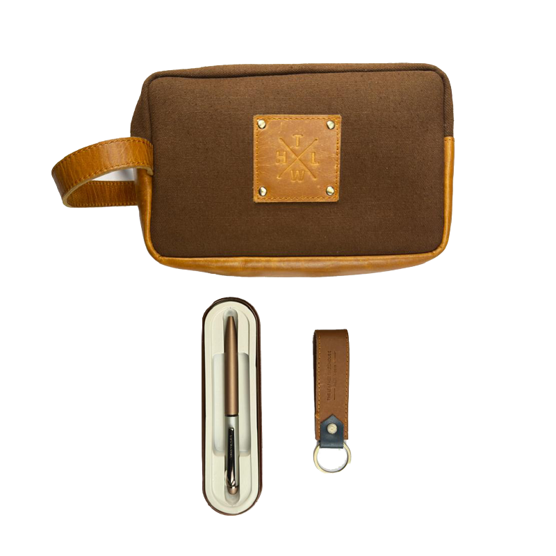 Brown toiletry bag with a pen holder and keychain on a white background