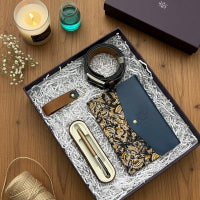 Gift set with wallet, pen, and other items on a wooden surface
