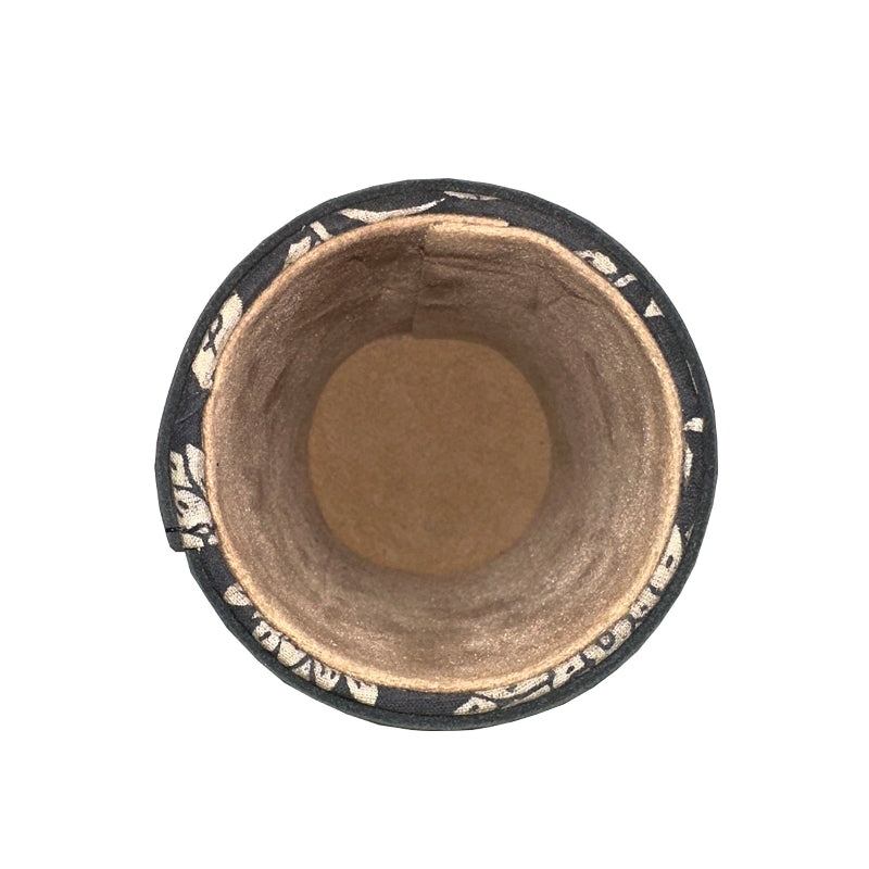 Top view of a black and gold decorative container with a brown interior on a white background