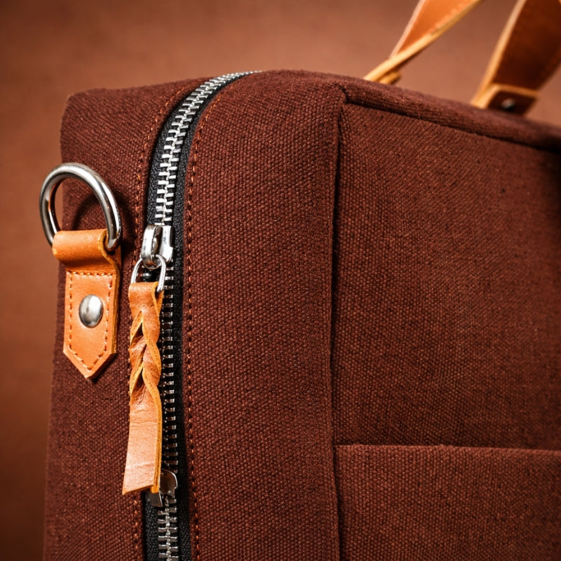 Brown bag with canvas &leather accents and zipper on a brown background