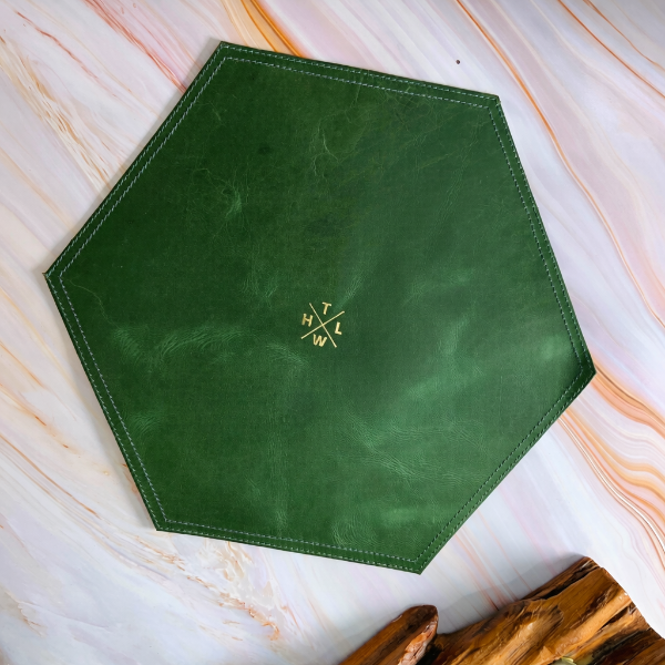 Green hexagonal placemat with a logo on a marble surface