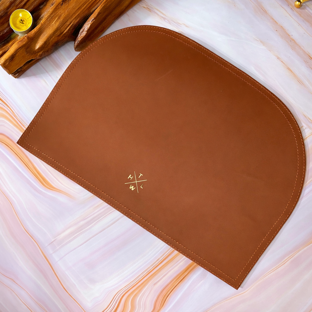 Brown leather placemat with a logo on a marble surface