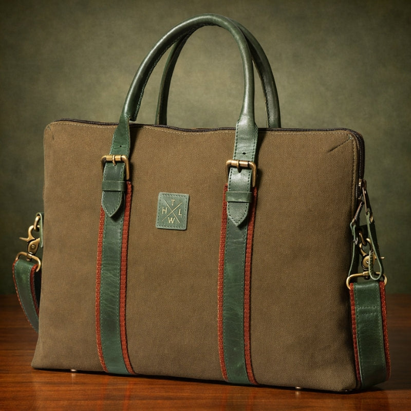 Brown canvas & leather bag with green straps on a wooden surface and dark background