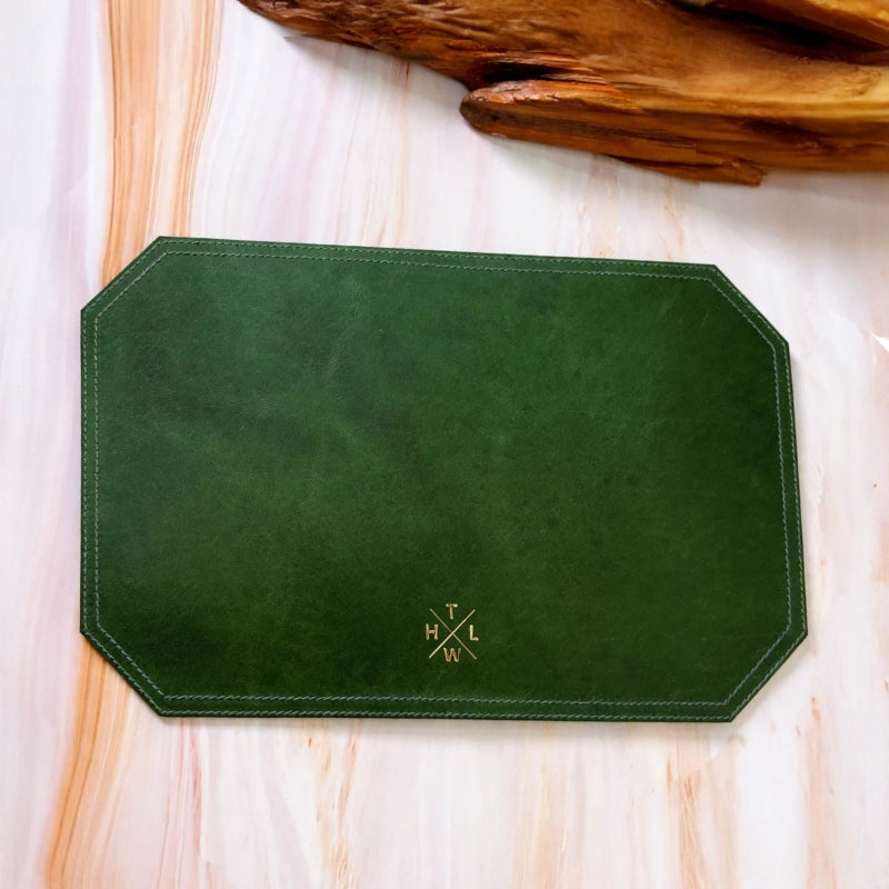 Green placemat with a logo on a wooden surface