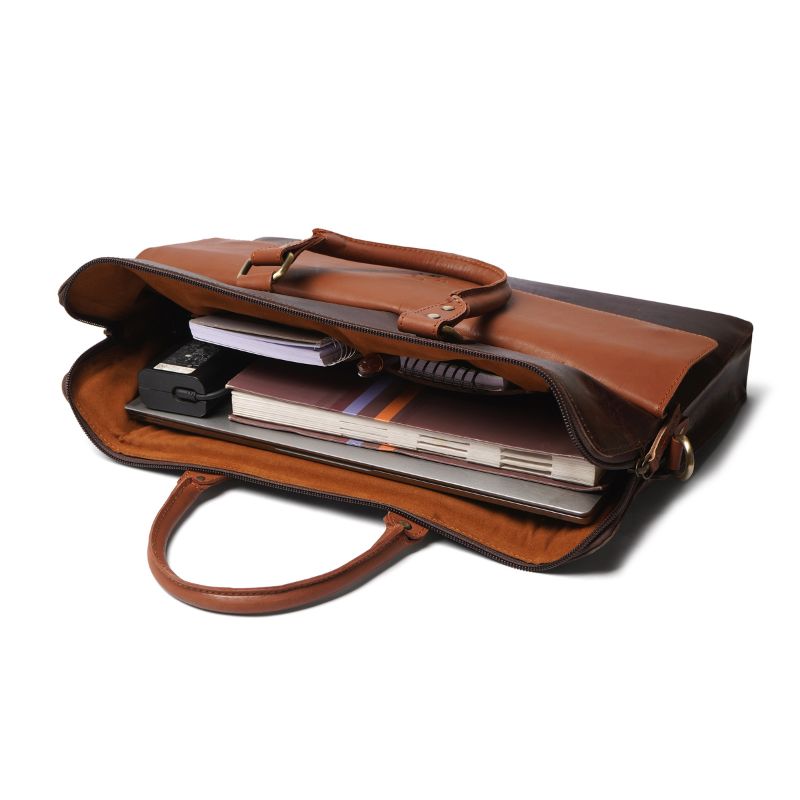 Brown leather laptop bag with items inside on a white background