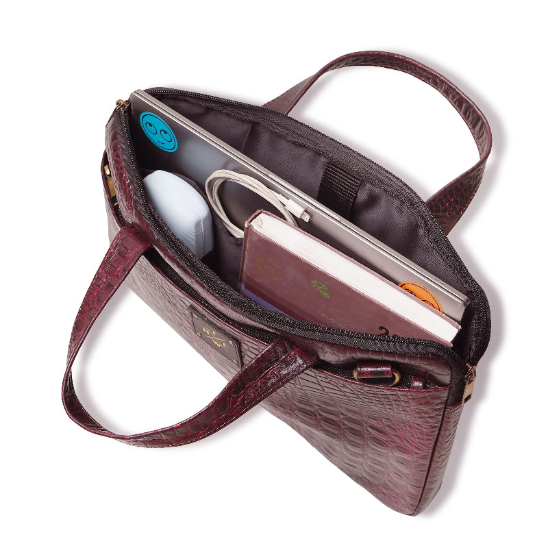 Brown leather handbag with interior compartments on a white background