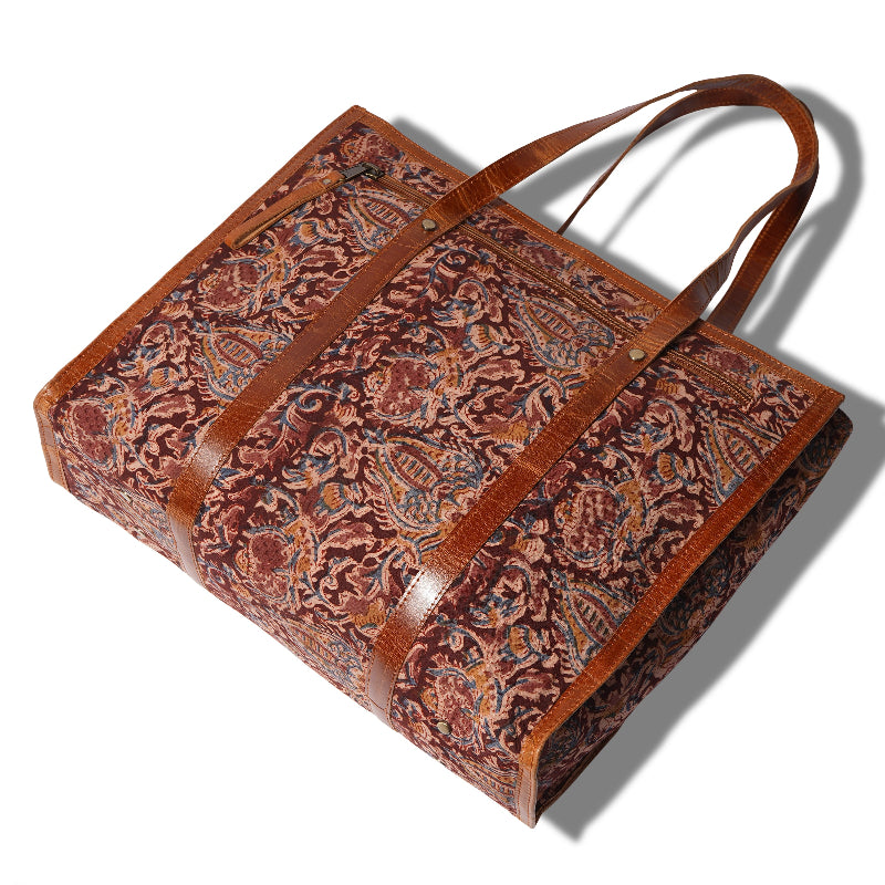 Brown leather bag with intricate pattern on a white background