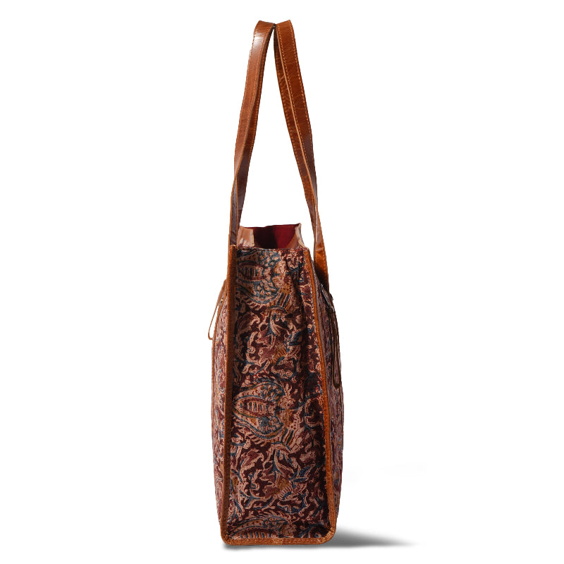 Brown leather tote bag with intricate patterns on a white background