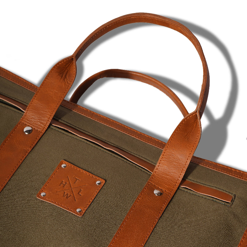 Brown leather tote bag with a visible brand logo on a white background