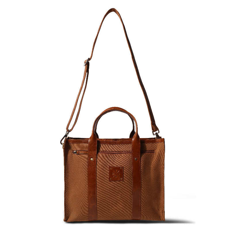 Brown leather tote bag with shoulder strap on a white background