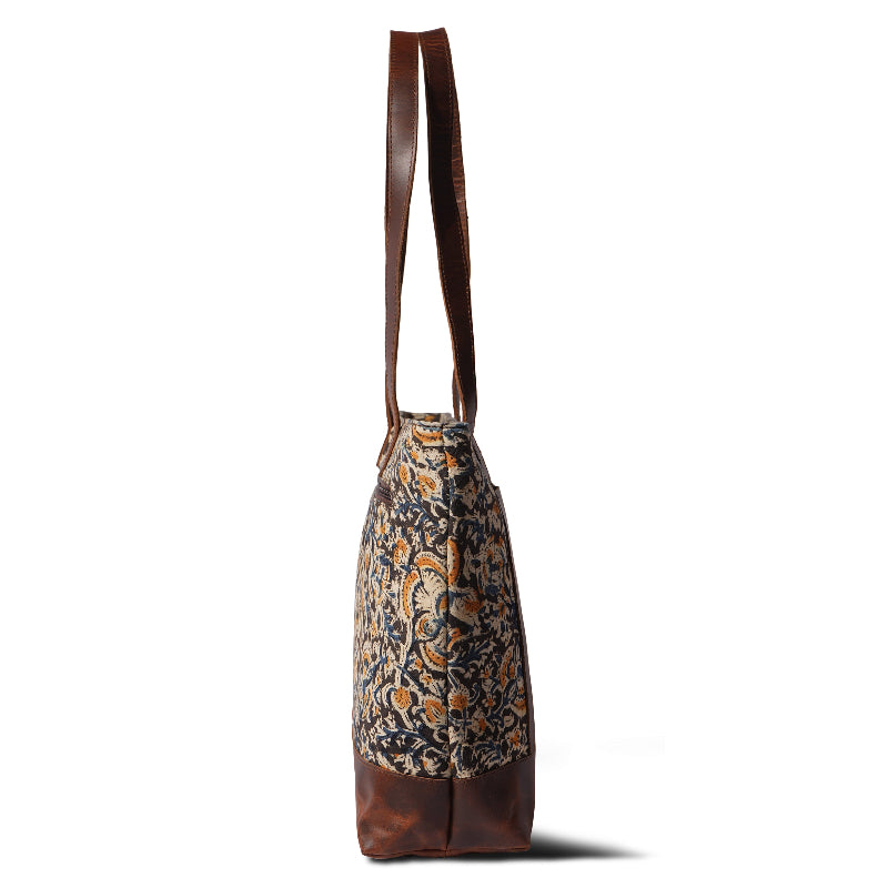 Patterned tote bag with brown leather handle on a white background