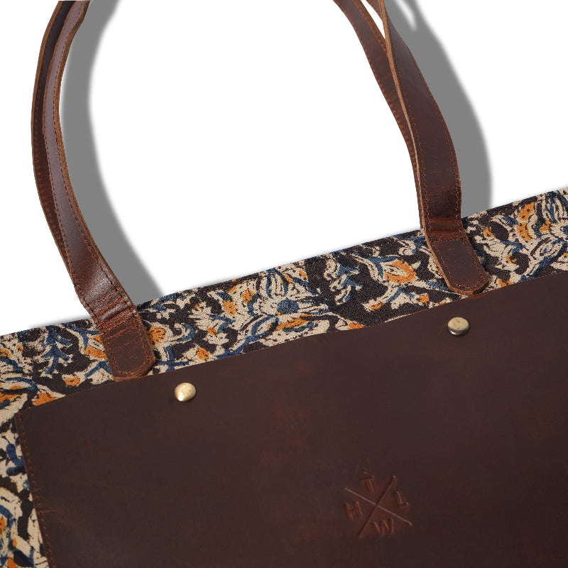 Brown leather bag with floral patterned lining on a white background