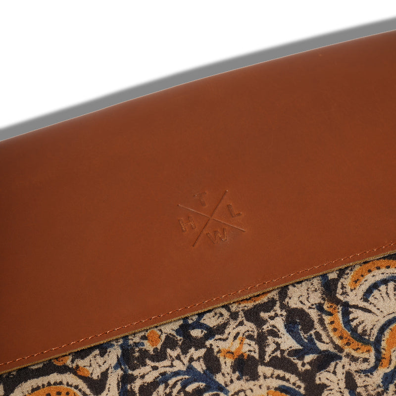 Close-up of a brown leather product with a patterned interior on a white background