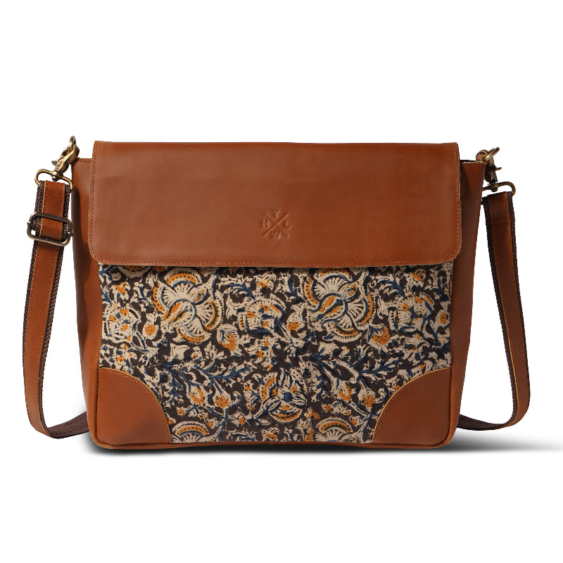 Brown leather bag with floral patterned flap on a white background