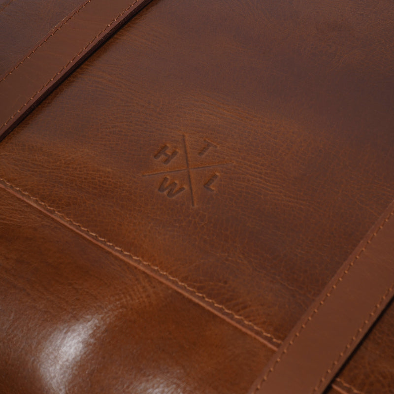 Close-up of a brown leather product with a visible brand logo.