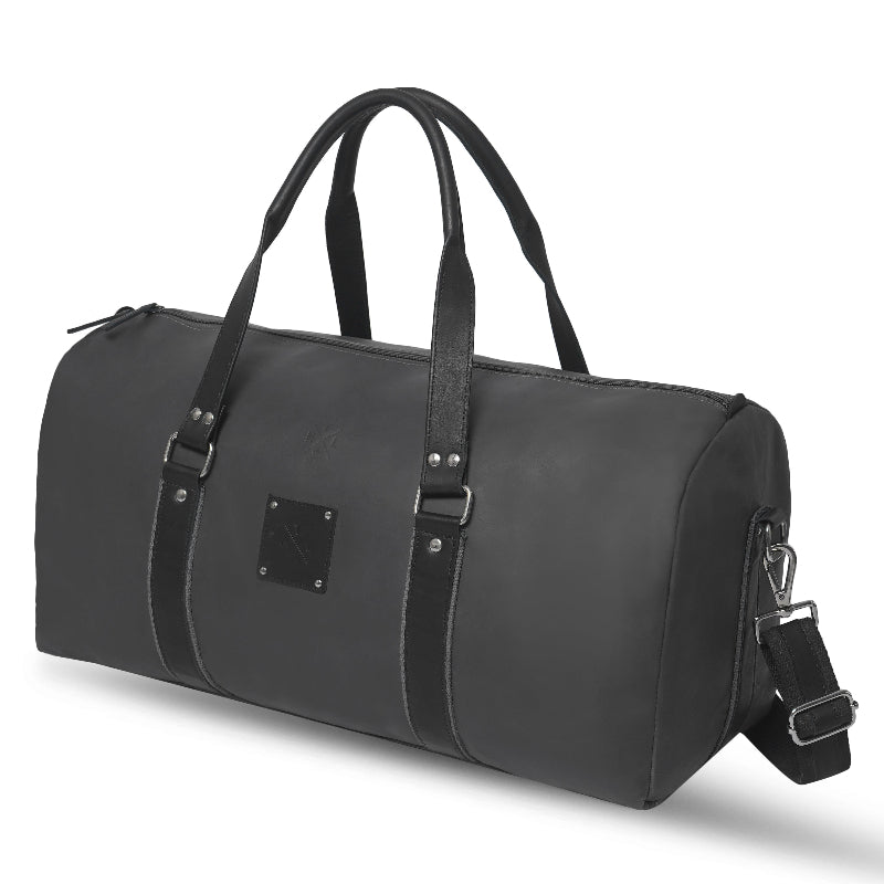 Black duffel bag with leather straps on a white background