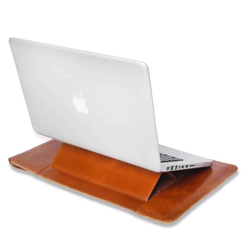 White laptop on a brown leather sleeve against a white background
