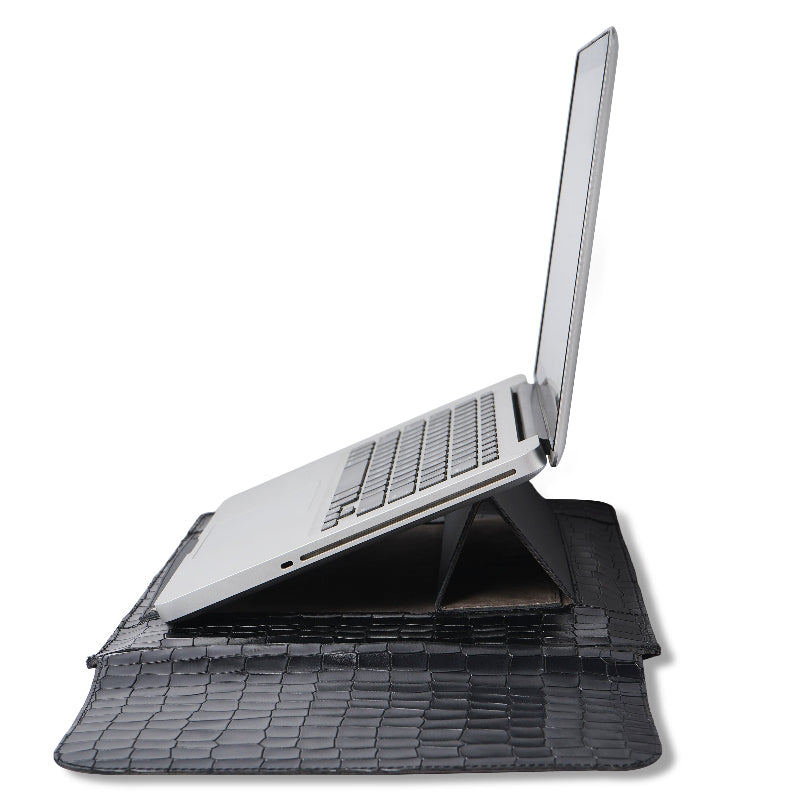 Laptop on a textured black stand sleeve  with a white background