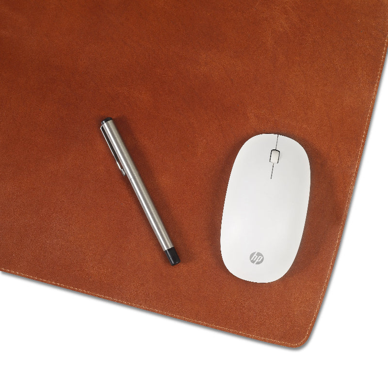 Brown leather mouse pad with a pen and white mouse on a white background