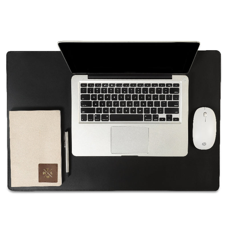 Laptop on a black desk with a mouse and notebook