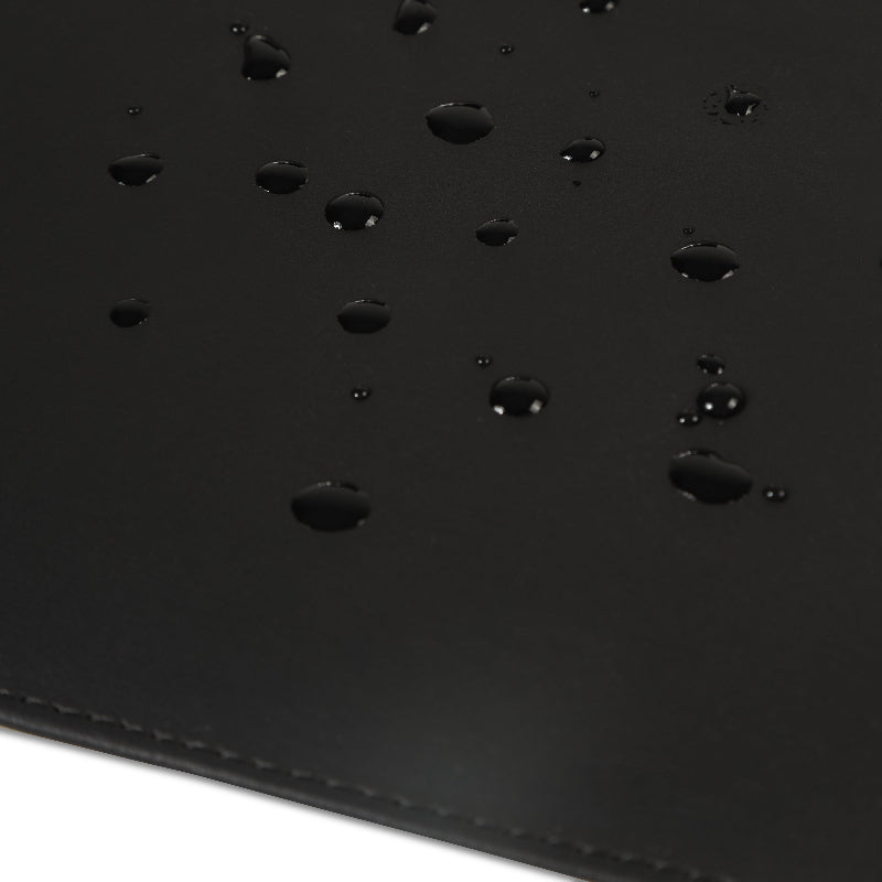 Black leather desk mat with water droplets on a white background