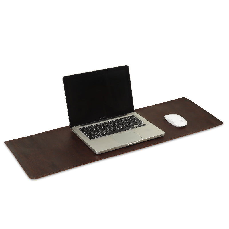 Laptop on a large brown desk pad with a mouse to the right on a white background