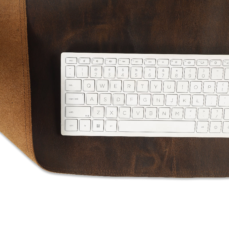 White keyboard on a brown leather desk mat