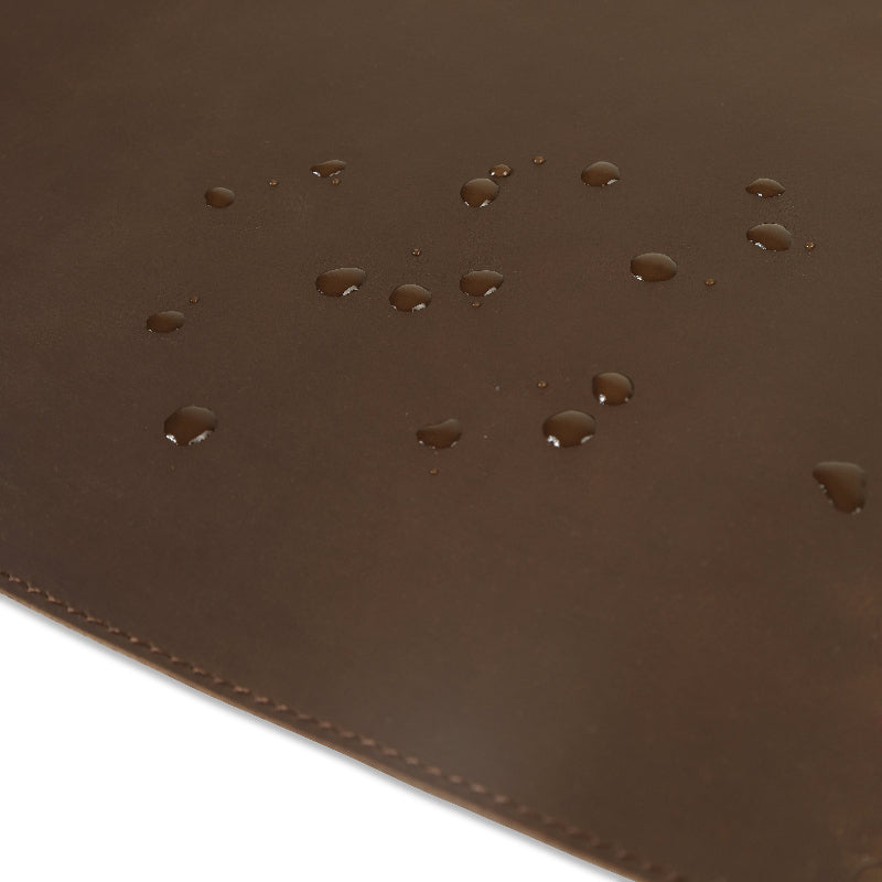 Close-up of a brown leather surface with water droplets.