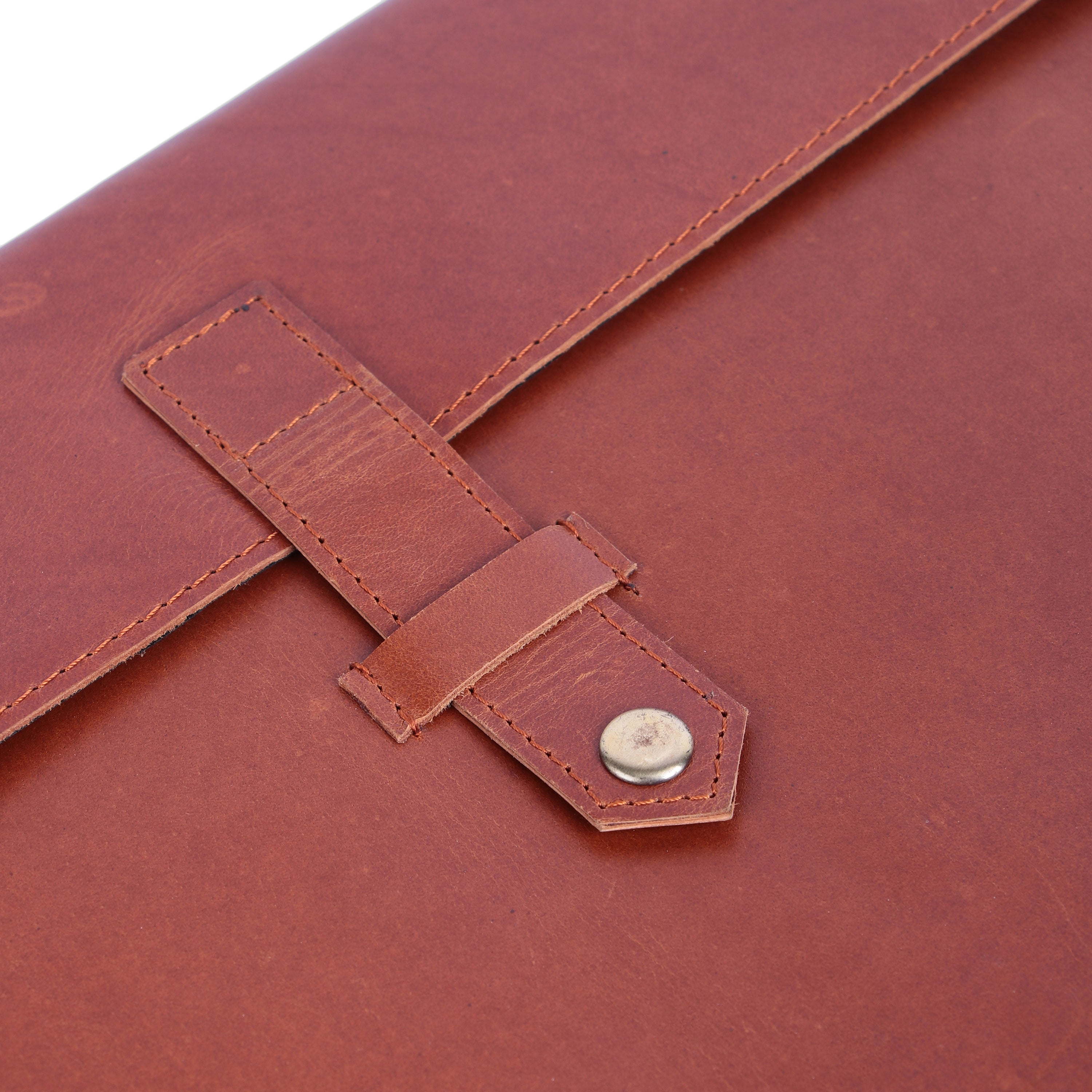 Close-up of a brown leather bag with a buckle detail on a white background