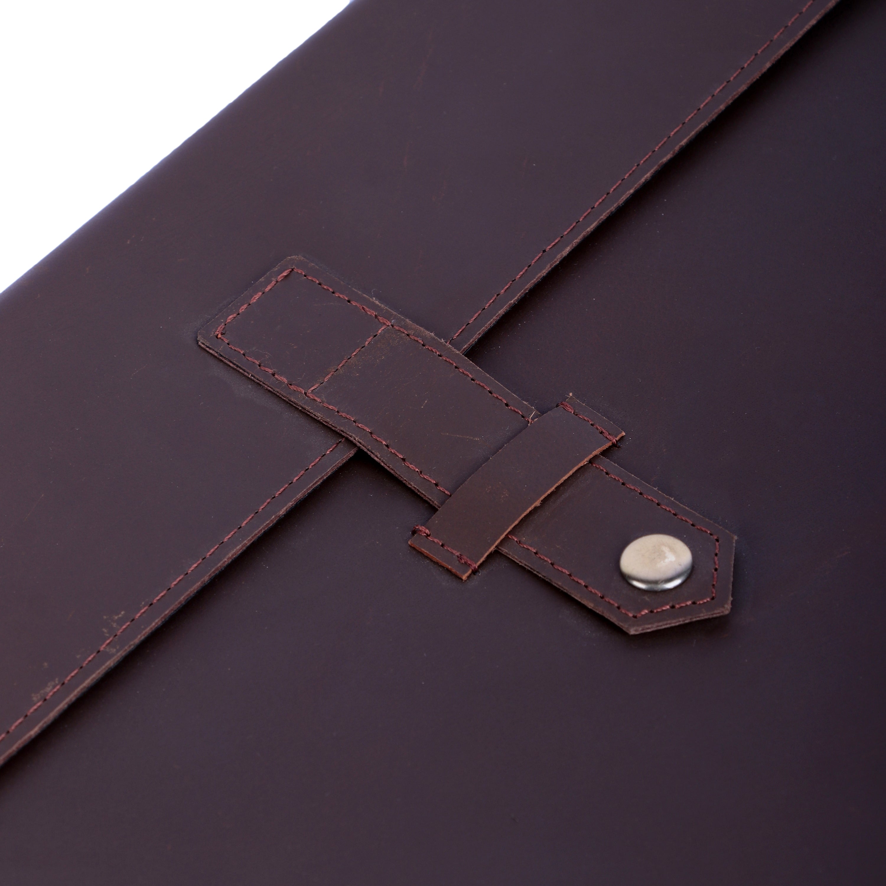Close-up of a brown leather strap with stitching detail on a matching brown background.
