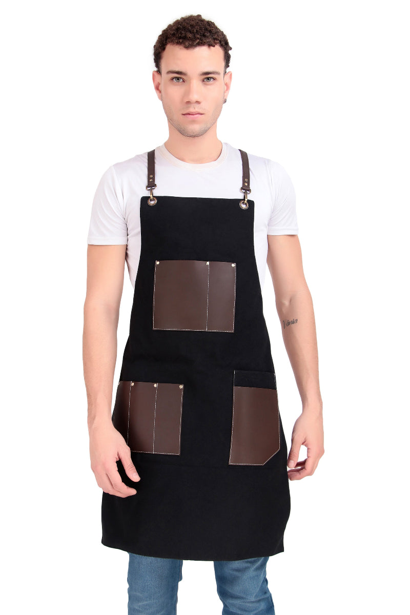 Person wearing a black apron with brown leather patches on a white background