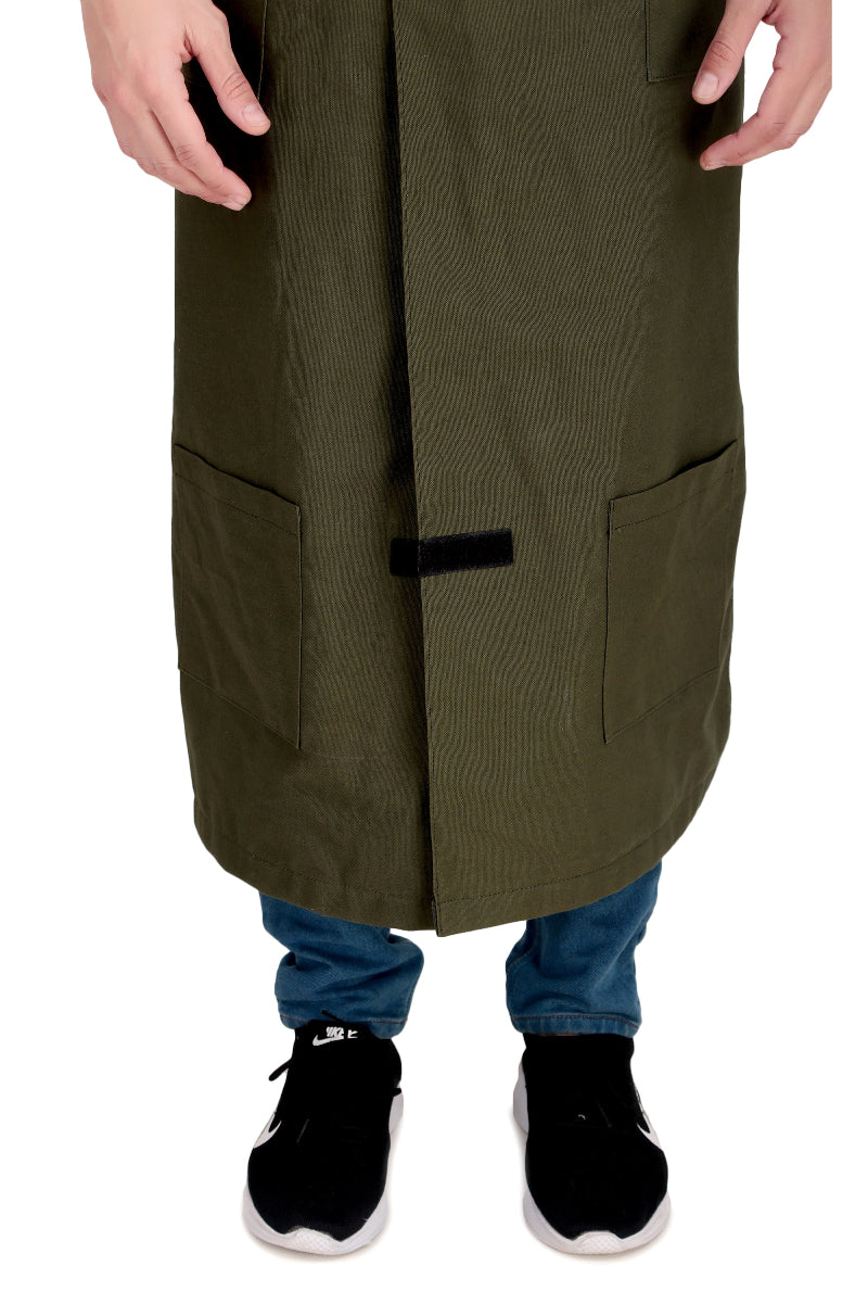 Person wearing a long green coat over blue pants with black shoes on a white background