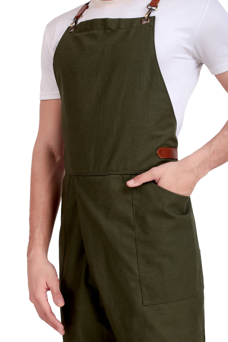 Person wearing a green apron with brown straps on a white background