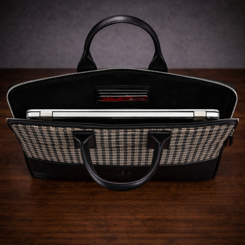 Black canvas & leather briefcase with a checkered interior on a wooden surface