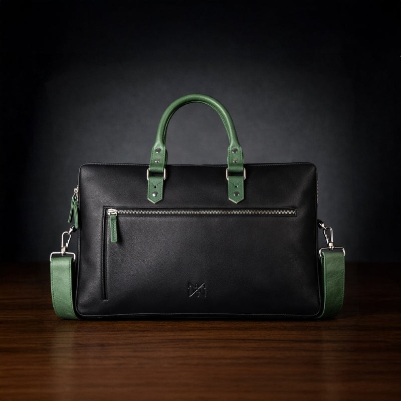 Black leather briefcase with green handles and straps on a dark background