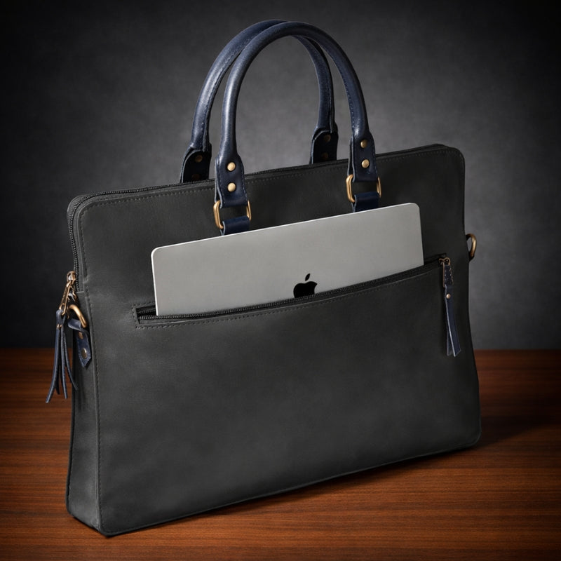 Black leather briefcase with a laptop inside on a wooden surface and dark background