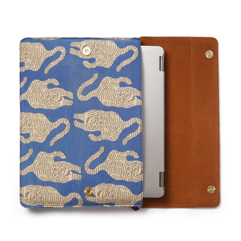 Tablet laptop sleeve with blue background and beige tiger pattern, next to a brown leather case.