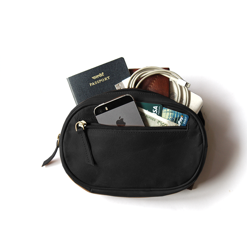Black pouch with items including a passport, phone, and money on a white background