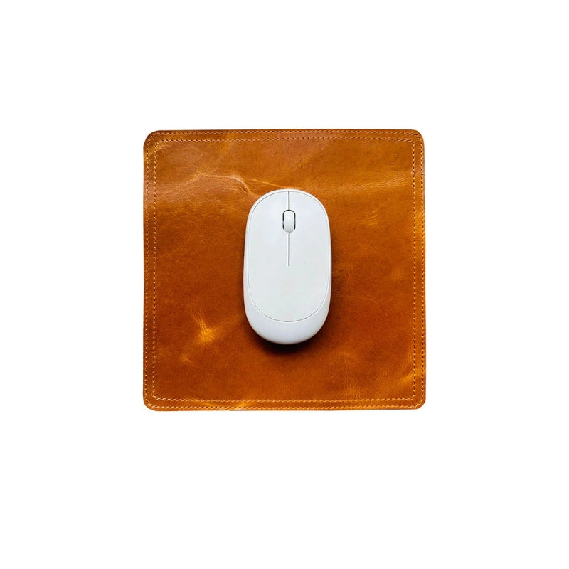 Brown leather mouse pad with a white computer mouse on a white background