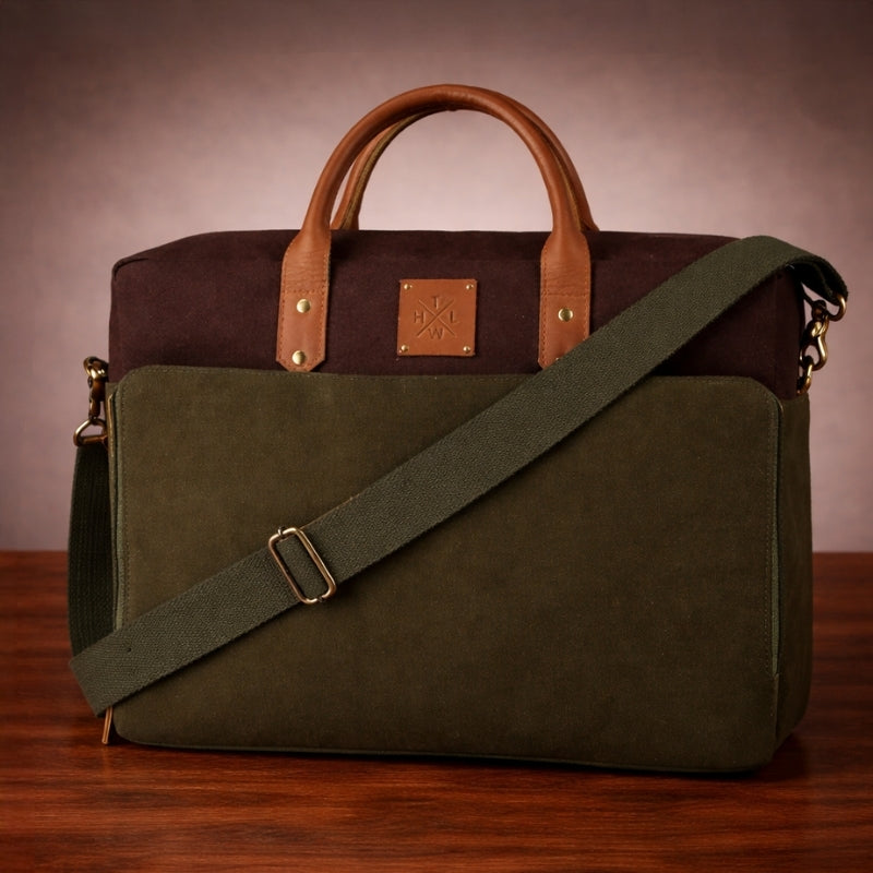 Green and brown leather & canvas bag with a shoulder strap on a wooden surface.