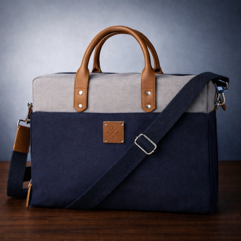 Two-toned bag with canvas handle and strap on a wooden surface